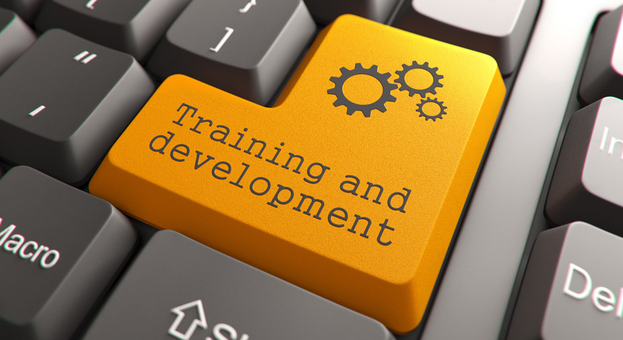Close-up of a keyboard with a highlighted orange key labeled “Training and development” and gear icons.