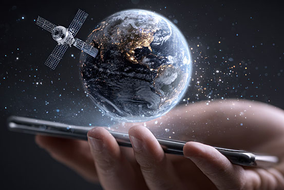 Hand holding a smartphone displaying a holographic Earth with a satellite orbiting it, symbolizing global connectivity and mobile technology.